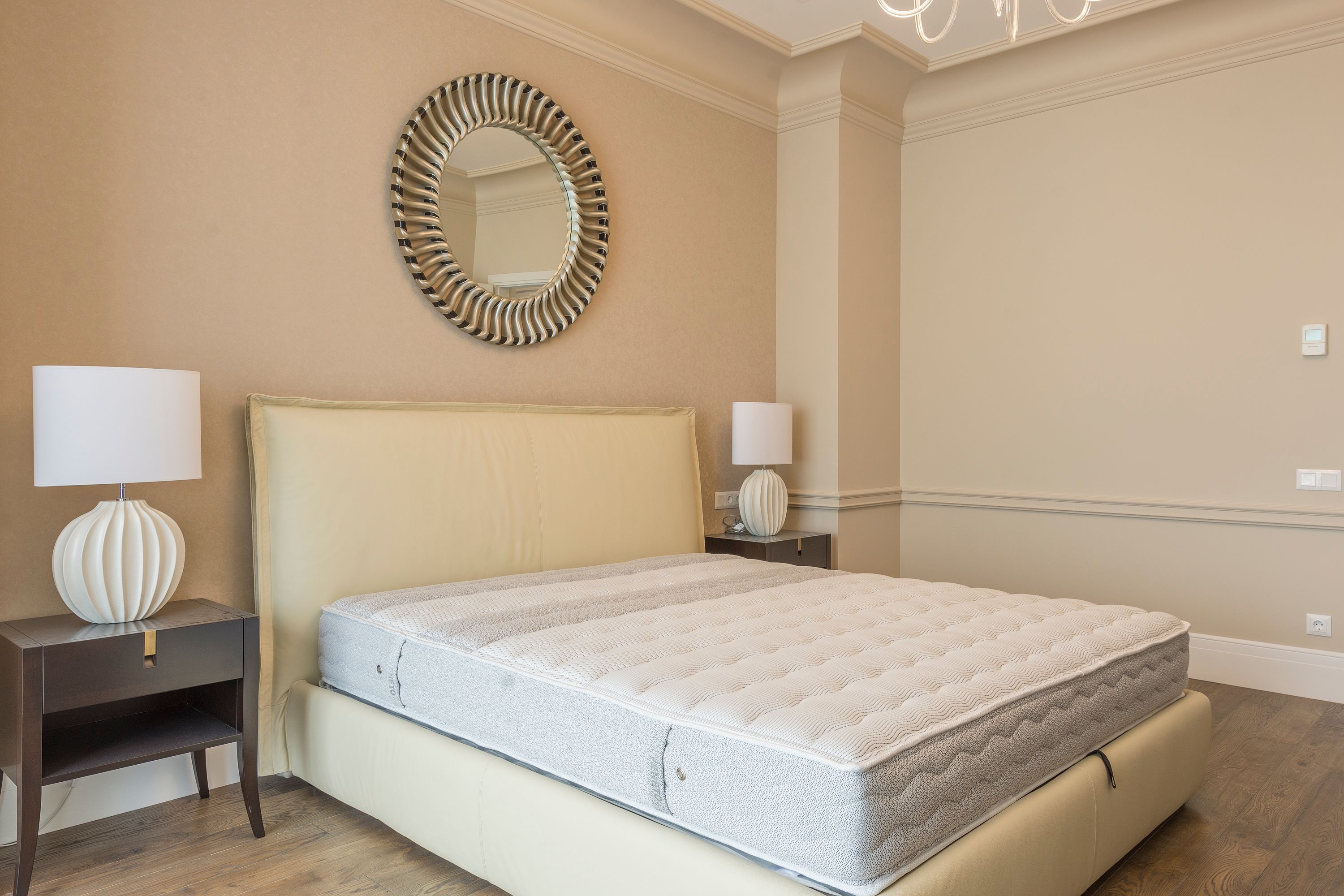 A tidy, neutral guest bedroom with a made bed, representing the kind of short-term rental room a host must inspect after a bed bug report.